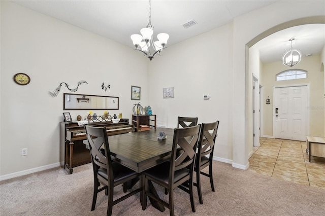 dining room with light carpet, baseboards, visible vents, arched walkways, and an inviting chandelier