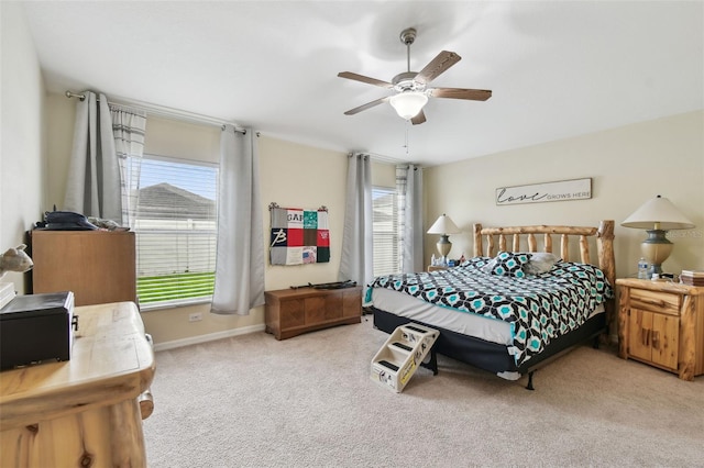 bedroom with light carpet, multiple windows, a ceiling fan, and baseboards