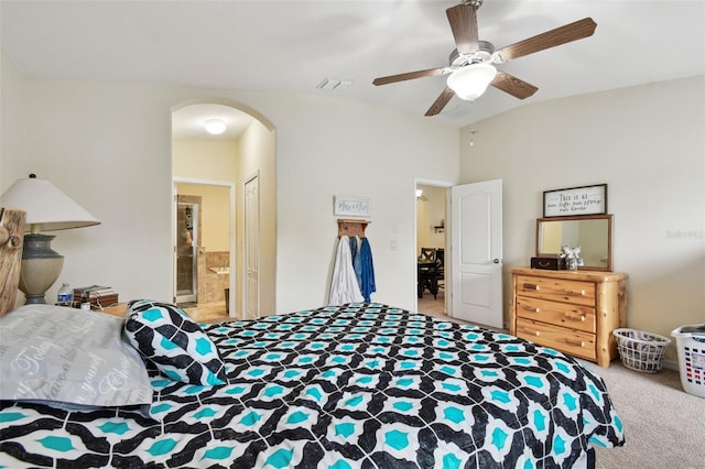 bedroom featuring carpet floors, arched walkways, a closet, ensuite bathroom, and ceiling fan