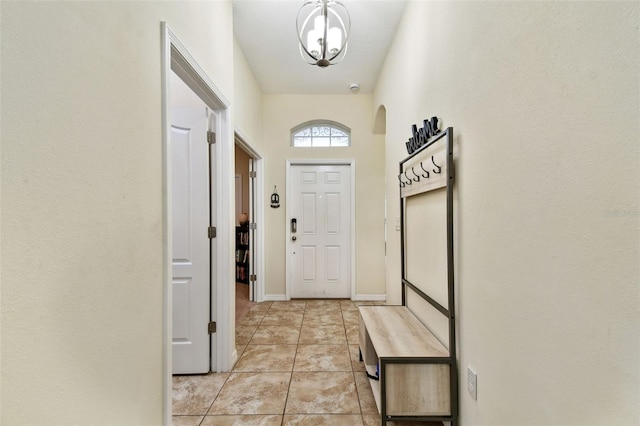 doorway with light tile patterned floors and baseboards