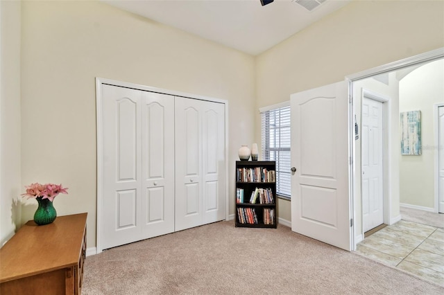 bedroom with visible vents, baseboards, a closet, and light colored carpet