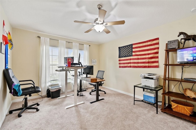 office featuring light carpet, ceiling fan, and baseboards