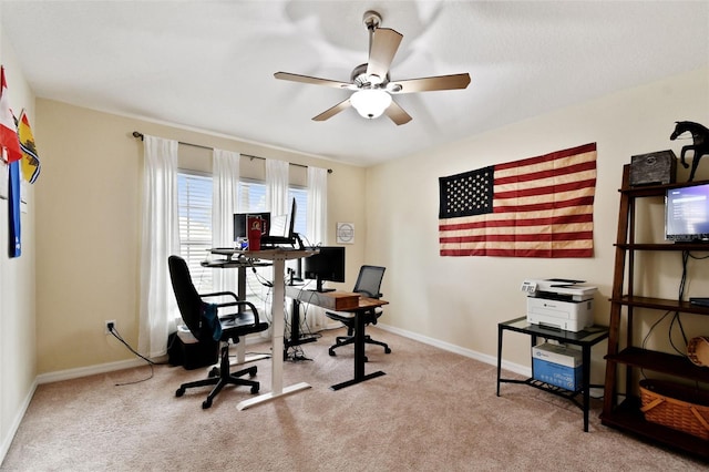 home office featuring ceiling fan, baseboards, and light colored carpet