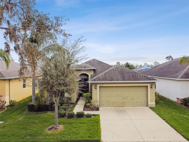 ranch-style house with a shingled roof, concrete driveway, a front lawn, and stucco siding