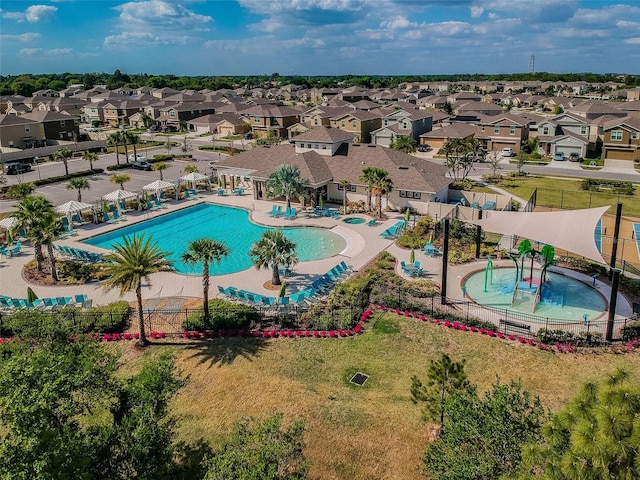 pool with a residential view, fence, and a lawn