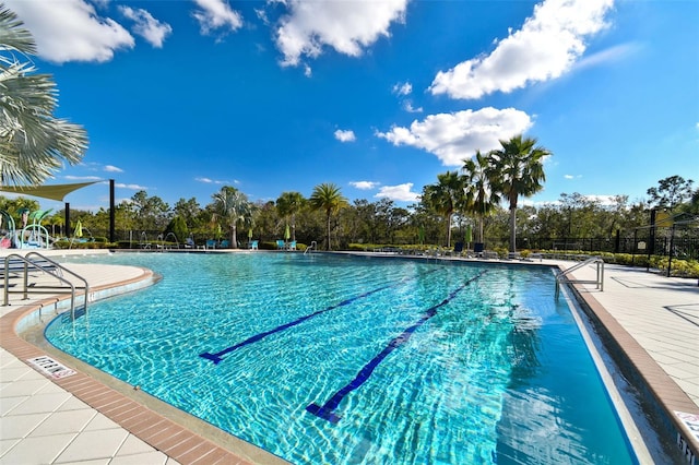 view of swimming pool featuring fence