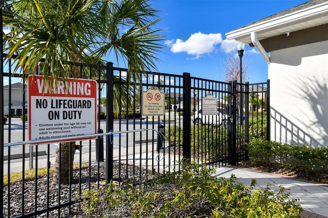 exterior space with a gate, fence, and stucco siding