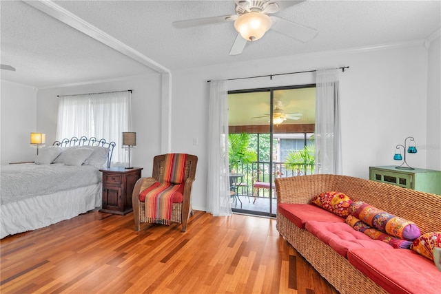 bedroom featuring a ceiling fan, access to outside, light wood-style flooring, and a textured ceiling