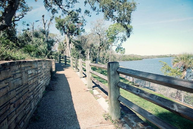 view of gate featuring a water view and fence