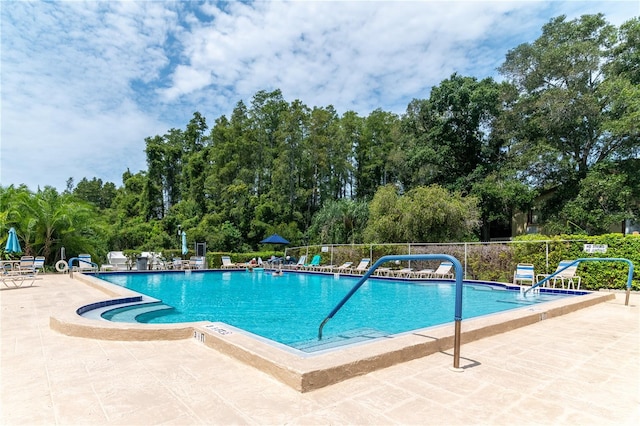 community pool featuring a patio area and fence