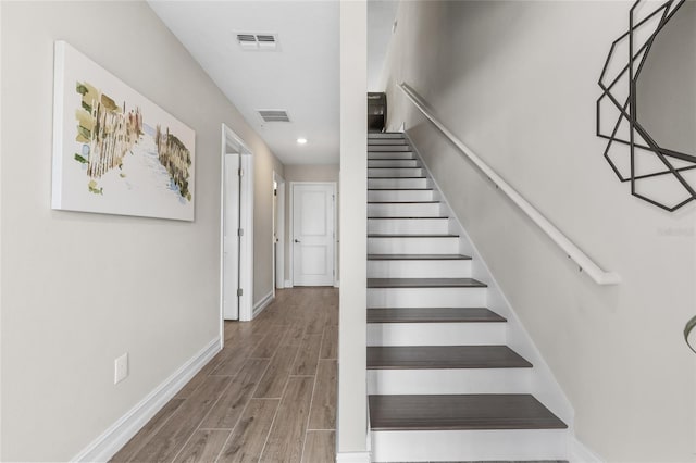 staircase with recessed lighting, wood finished floors, visible vents, and baseboards