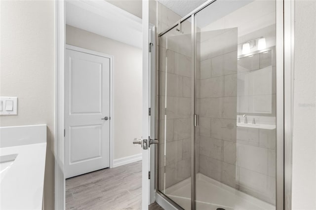 bathroom featuring a stall shower, wood finished floors, and vanity