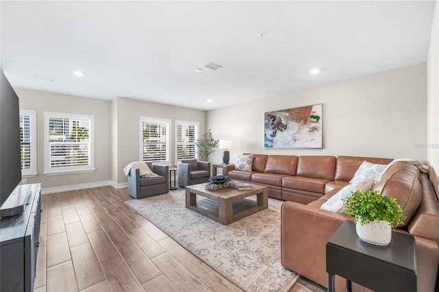 living room with baseboards, visible vents, wood finished floors, and recessed lighting