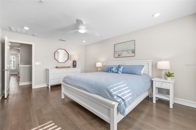 bedroom with ceiling fan, dark wood finished floors, visible vents, and baseboards