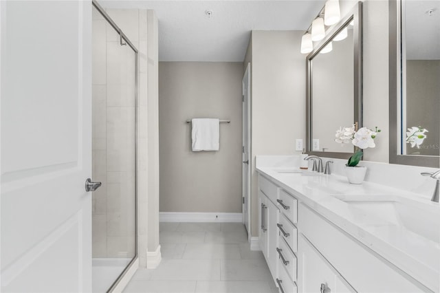 full bathroom with a stall shower, a sink, and baseboards