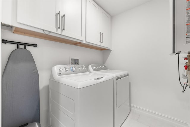 clothes washing area featuring cabinet space, washing machine and dryer, light tile patterned floors, and baseboards