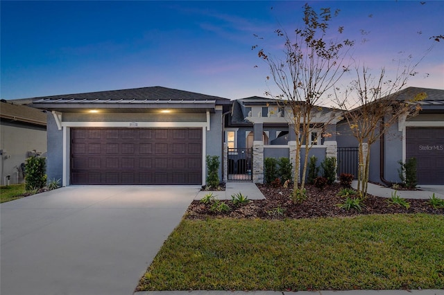 view of front of home with a yard, stucco siding, an attached garage, fence, and driveway