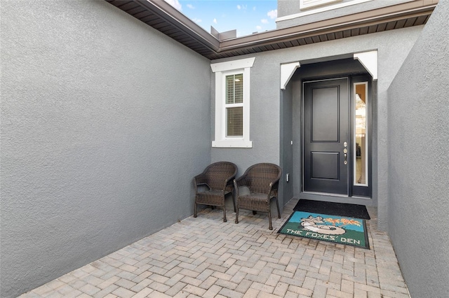 view of exterior entry featuring stucco siding