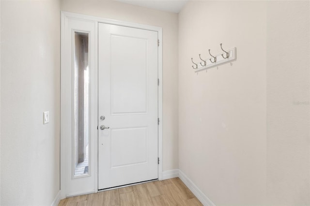 doorway to outside with baseboards and light wood-style floors