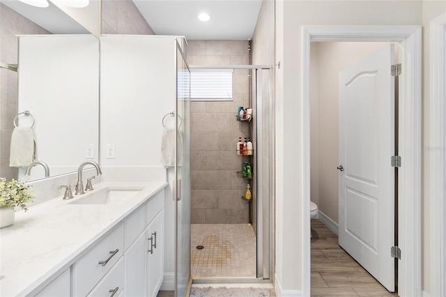 full bath with toilet, a shower stall, wood tiled floor, and vanity