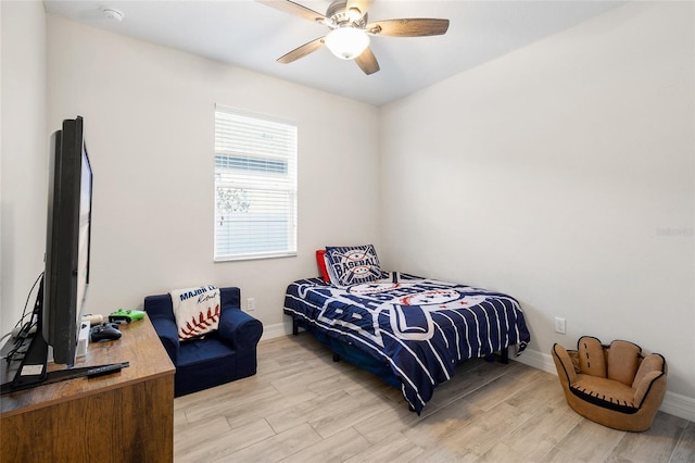 bedroom featuring ceiling fan, light wood-style flooring, and baseboards