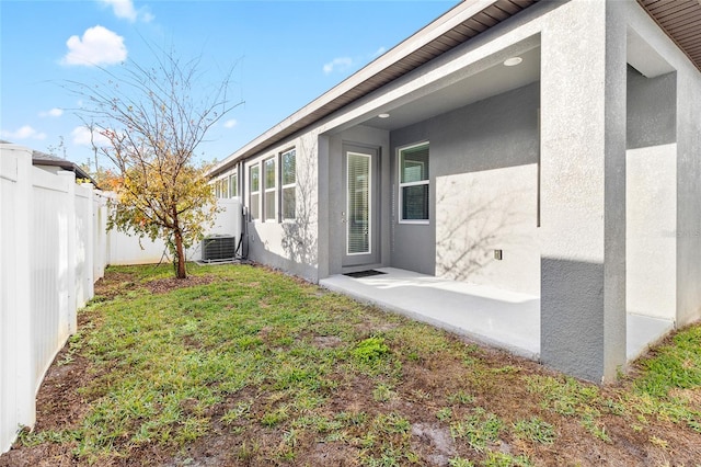 exterior space featuring a patio area, a fenced backyard, and central AC