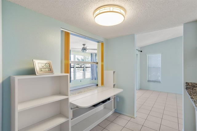 interior space featuring light tile patterned flooring and a textured ceiling