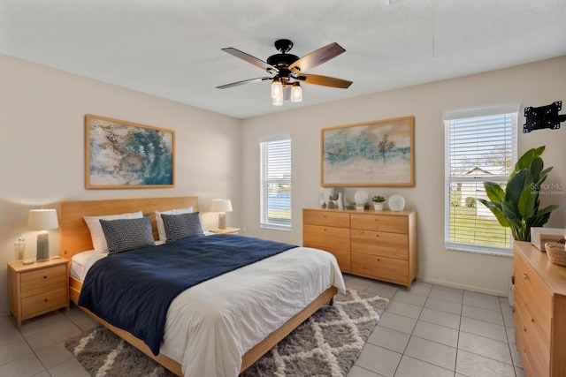 bedroom featuring multiple windows, baseboards, and light tile patterned flooring