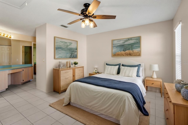 bedroom with light tile patterned floors, visible vents, and a ceiling fan