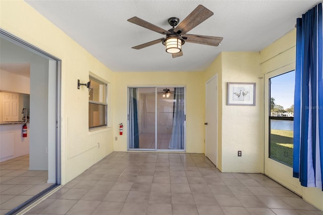 interior space featuring a sunroom, a textured ceiling, and tile patterned floors