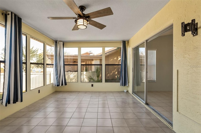 unfurnished sunroom with ceiling fan