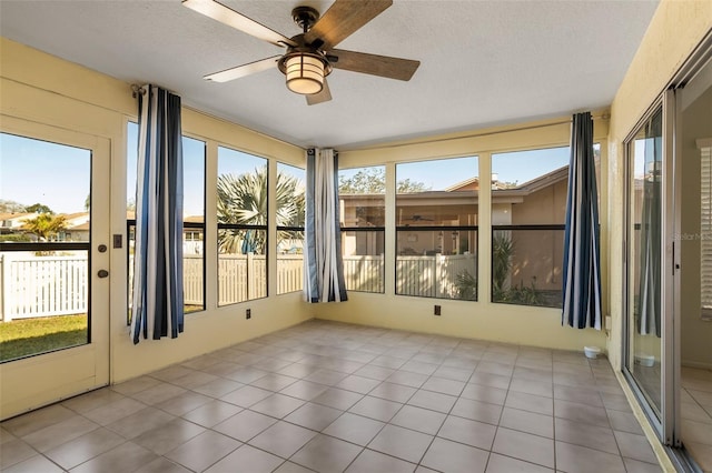 unfurnished sunroom with a ceiling fan