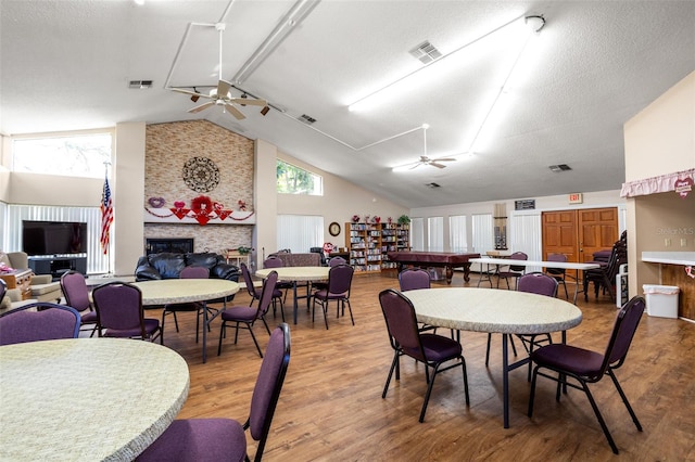 dining room with light wood-style floors, a fireplace, and visible vents