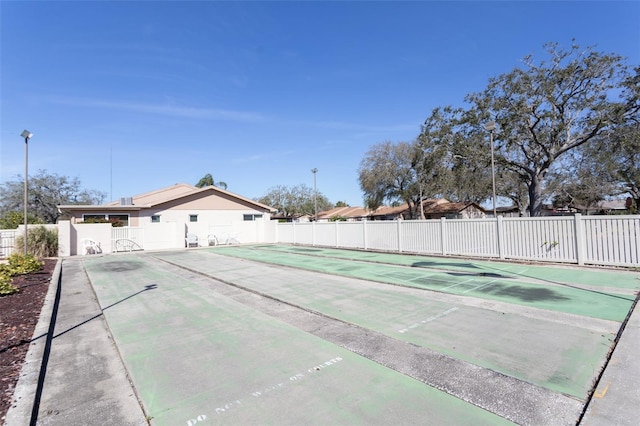 view of home's community with fence and shuffleboard