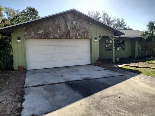 ranch-style home with concrete driveway and an attached garage