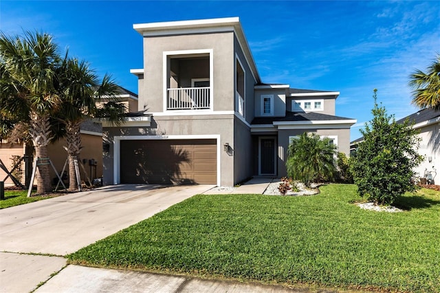 view of front of home with an attached garage, a balcony, concrete driveway, stucco siding, and a front lawn