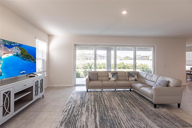 living room with plenty of natural light, baseboards, and light tile patterned floors