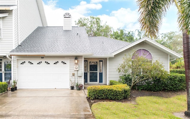 view of front of property featuring concrete driveway, a shingled roof, a chimney, and an attached garage