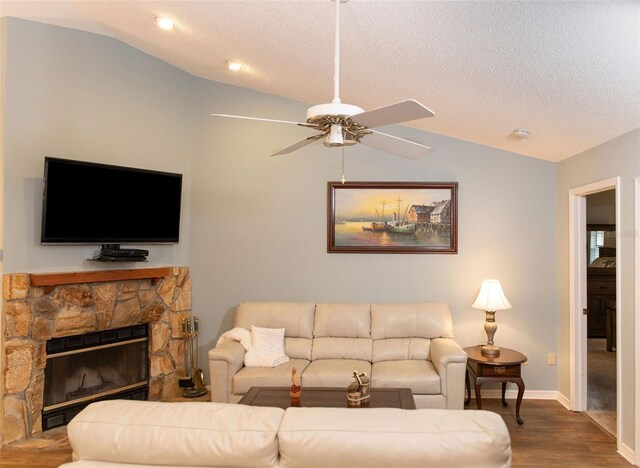 living area with ceiling fan, a textured ceiling, vaulted ceiling, and wood finished floors