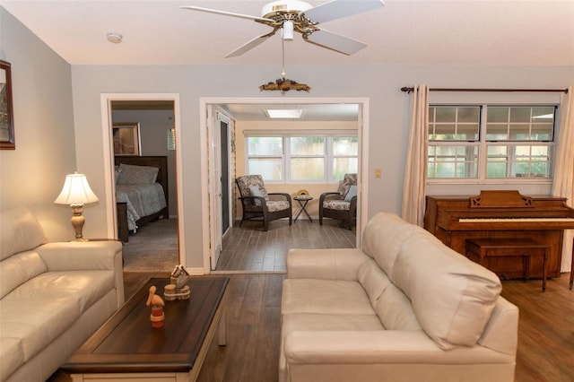 living area with dark wood-style flooring and ceiling fan