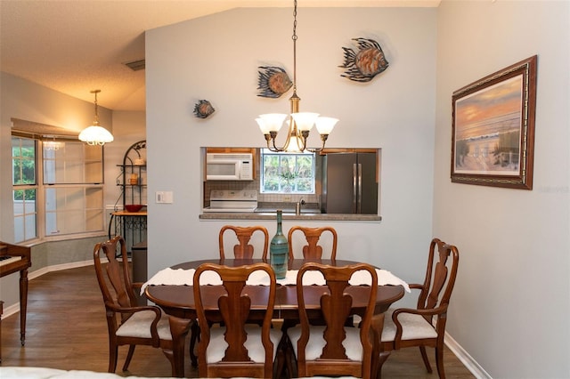 dining space featuring vaulted ceiling, baseboards, dark wood finished floors, and an inviting chandelier