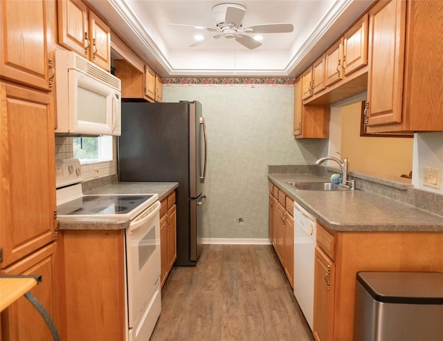 kitchen with white appliances, light countertops, crown molding, light wood-type flooring, and a sink