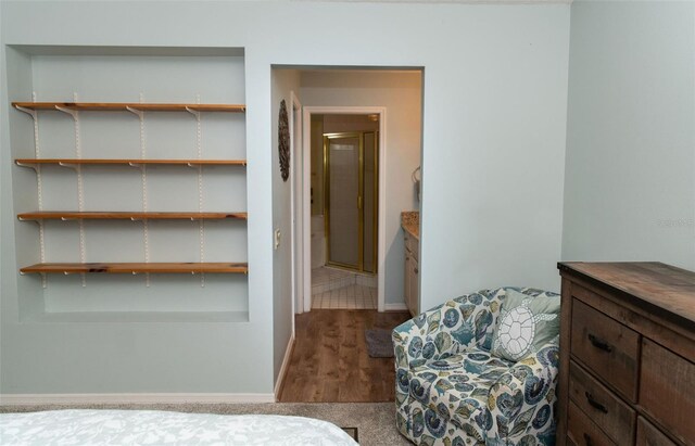 bedroom with wood finished floors and baseboards