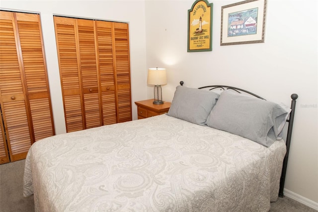 bedroom featuring carpet floors, baseboards, and multiple closets