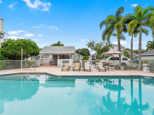 pool with a patio and fence