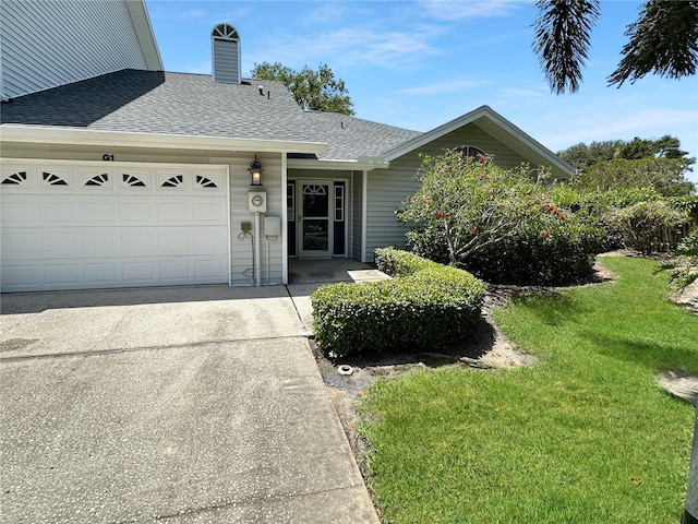 11722 Currie Ln Unit G1, Largo, FL 33774 - view of front facade with roof with shingles, driveway, an attached garage, and a front lawn