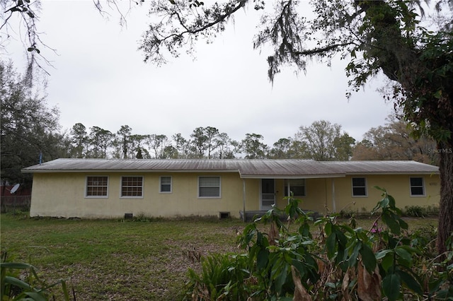 rear view of house with metal roof and stucco siding