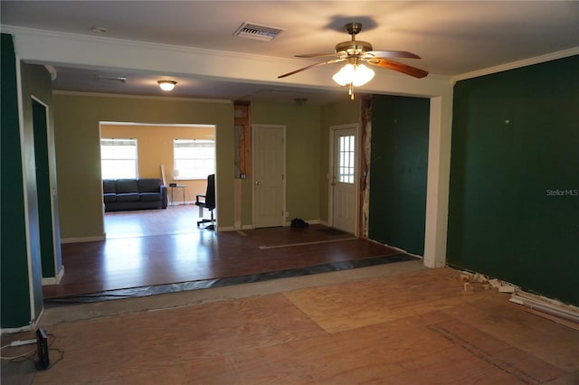 interior space featuring visible vents, ornamental molding, ceiling fan, and baseboards