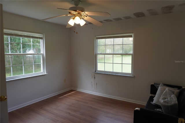 spare room with ceiling fan, baseboards, and wood finished floors