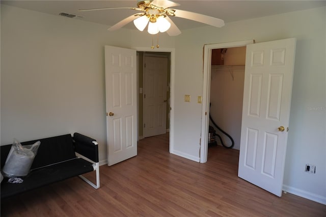 living area with baseboards, visible vents, and wood finished floors